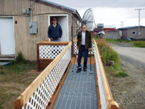 Older man with canes on a newly constructed accessibilityramp